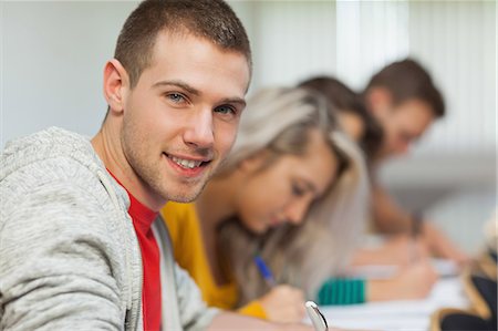 simsearch:6109-07497606,k - Smiling attractive student looking at camera at college Foto de stock - Sin royalties Premium, Código: 6109-07497543