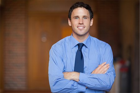 string (clothing) - Lucky handsome lecturer looking at camera in hallway in a college Stock Photo - Premium Royalty-Free, Code: 6109-07497574