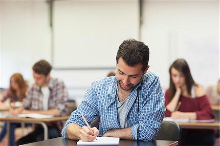 simsearch:6109-07497673,k - Focused student taking notes in class at the university Stock Photo - Premium Royalty-Free, Code: 6109-07497581