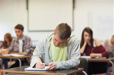 Focused young student taking notes in class at the university Stock Photo - Premium Royalty-Free, Code: 6109-07497582