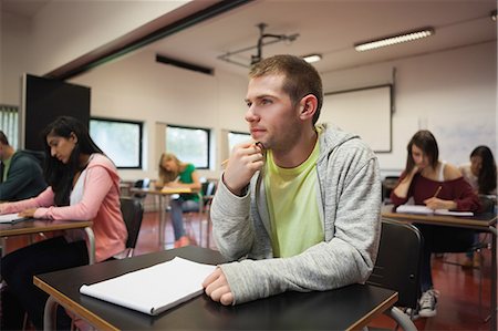 student thinking in a classroom - Smiling male student listening intently in class at the university Stock Photo - Premium Royalty-Free, Code: 6109-07497590