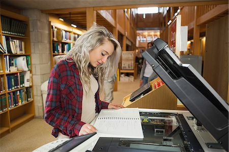 simsearch:6109-07497515,k - Focused blonde student standing next to photocopier in library in a college Photographie de stock - Premium Libres de Droits, Code: 6109-07497515