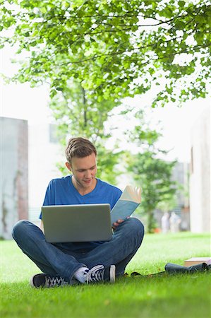 Focused handsome student sitting under tree studying on college campus Photographie de stock - Premium Libres de Droits, Code: 6109-07497524