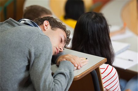 simsearch:6109-07497651,k - Male student sleeping in a lecture hall in college Stock Photo - Premium Royalty-Free, Code: 6109-07497651