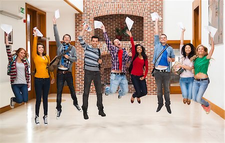 Happy students jumping for joy holding exam results in a hallway at the university Photographie de stock - Premium Libres de Droits, Code: 6109-07497628