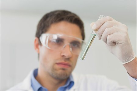 pharmacy lab - Young male scientist looking at small test tube in laboratory Stock Photo - Premium Royalty-Free, Code: 6109-07497753