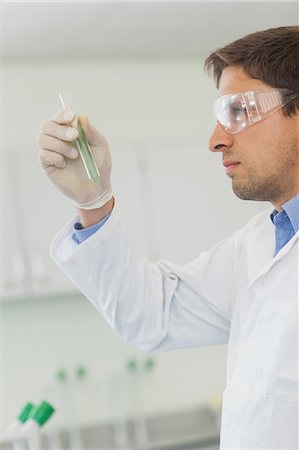 examen (scolaire) - Profile view of young male scientist looking at small test tube in laboratory Photographie de stock - Premium Libres de Droits, Code: 6109-07497755