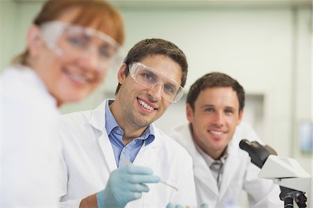 exams college - Three young scientists being in a laboratory  smiling at camera Stock Photo - Premium Royalty-Free, Code: 6109-07497769