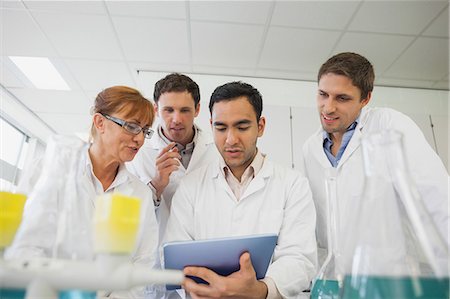Low angle view of some scientists looking at a tablet standing in a laboratory Photographie de stock - Premium Libres de Droits, Code: 6109-07497785