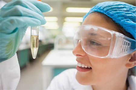 Smiling student looking closely at test tube in lab at college Foto de stock - Sin royalties Premium, Código: 6109-07497798