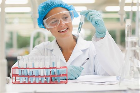 simsearch:6109-07497806,k - Smiling student holding test tube containing liquid in lab at college Fotografie stock - Premium Royalty-Free, Codice: 6109-07497802