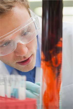 simsearch:6109-07497806,k - Amazed student watching purple liquid mixing with red in lab at college Fotografie stock - Premium Royalty-Free, Codice: 6109-07497810