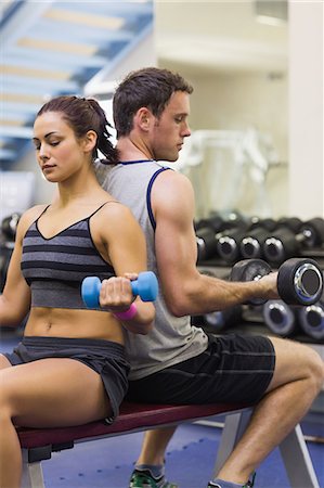 simsearch:6109-07497902,k - Sporty woman and man lifting dumbbells in weights room of gym Photographie de stock - Premium Libres de Droits, Code: 6109-07497941