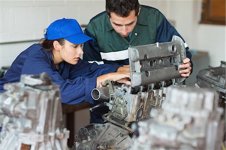 Focused trainee repairing engine with instructor in workshop Photographie de stock - Premium Libres de Droits, Code: 6109-07497949