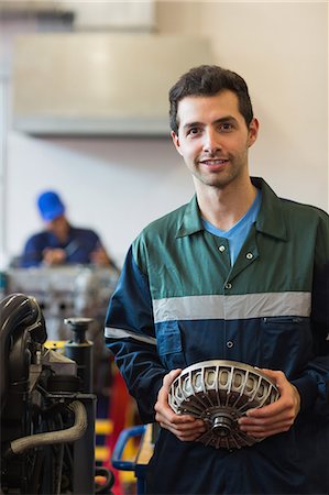 female mechanic portrait - Happy instructor holding machine part in workshop Photographie de stock - Premium Libres de Droits, Code: 6109-07497960