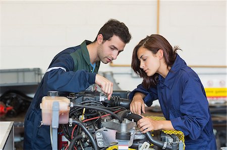 simsearch:6109-07497984,k - Concentrating instructor and trainee checking a machine in workshop Foto de stock - Sin royalties Premium, Código: 6109-07497964