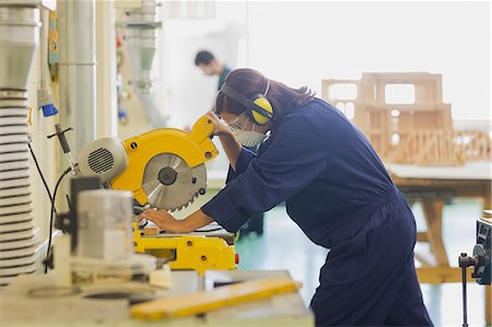 Focused trainee sawing wood in workshop Photographie de stock - Premium Libres de Droits, Code: 6109-07497978