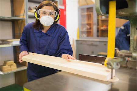 Apprentice wearing safety protection using saw in workshop Foto de stock - Sin royalties Premium, Código: 6109-07497999