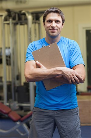 simsearch:858-05799219,k - Portrait of a smiling trainer with clipboard standing in the gym Stock Photo - Premium Royalty-Free, Code: 6109-07498067