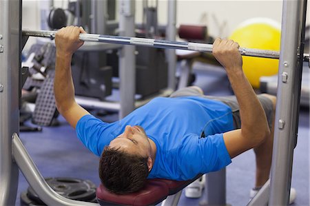 pesado - Young fit man lifting the barbell bench press in the gym Foto de stock - Sin royalties Premium, Código: 6109-07498071