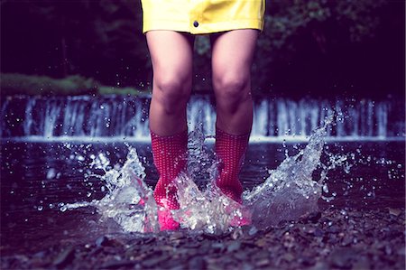 rain boots jump - Close up low section of a woman in red gumboots jumping in water Stock Photo - Premium Royalty-Free, Code: 6109-07498075