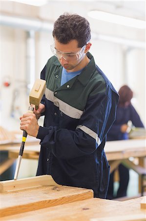 simsearch:6109-07497958,k - Carpenter using mallet and chisel in workshop Photographie de stock - Premium Libres de Droits, Code: 6109-07498001