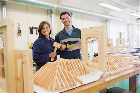 Happy trainee and instructor standing behind construction in workshop Photographie de stock - Premium Libres de Droits, Code: 6109-07498004
