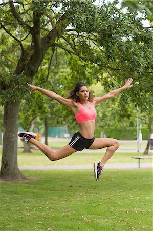 simsearch:6109-08203012,k - Full length of a toned young woman jumping in the park Foto de stock - Sin royalties Premium, Código: 6109-07498037