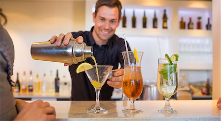 Smiling bartender preparing a drink at bar counter Stock Photo - Premium Royalty-Free, Code: 6109-07600944