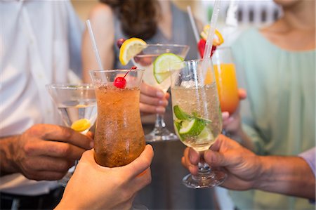 friends enjoying cocktail - Closeup mid section of people toasting cocktails Stock Photo - Premium Royalty-Free, Code: 6109-07600925