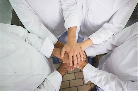 simsearch:6109-07601043,k - Team of chefs putting their hands together Stock Photo - Premium Royalty-Free, Code: 6109-07601045