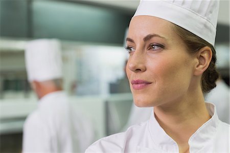 simsearch:6109-08489857,k - Serious chef looking away with team working behind Stock Photo - Premium Royalty-Free, Code: 6109-07601051