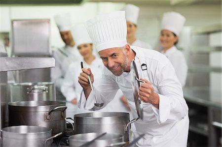 simsearch:6109-07601168,k - Head chef smelling pot of soup and smiling at camera Stockbilder - Premium RF Lizenzfrei, Bildnummer: 6109-07601061