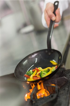 flaming cook - Chef frying vegetables in a wok Foto de stock - Sin royalties Premium, Código: 6109-07601080