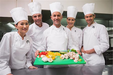 simsearch:6109-07601132,k - Head chef showing board of vegetables with trainees Stock Photo - Premium Royalty-Free, Code: 6109-07601093