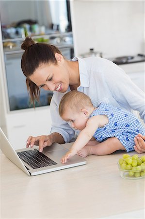 simsearch:6109-07601002,k - Mother with baby using laptop at counter Photographie de stock - Premium Libres de Droits, Code: 6109-07601029