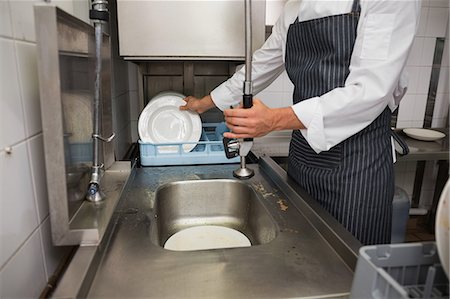 simsearch:6109-07601170,k - Kitchen porter cleaning plates in sink Photographie de stock - Premium Libres de Droits, Code: 6109-07601148