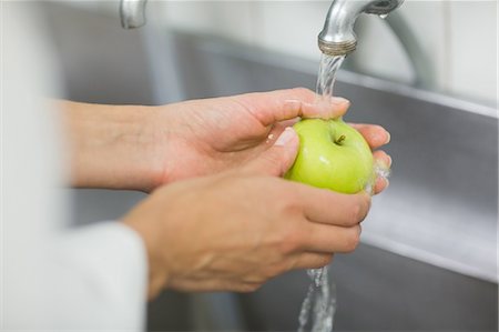 profesional (deportes y artes) - Chef washing apple under the tap Foto de stock - Sin royalties Premium, Código: 6109-07601157