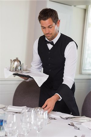 simsearch:6109-07601180,k - Waiter holding tray and setting table Stock Photo - Premium Royalty-Free, Code: 6109-07601182