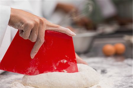 simsearch:6109-07601051,k - Chef preparing dough at counter Foto de stock - Sin royalties Premium, Código: 6109-07601114