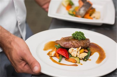 delicious food - Chef holding steak dinner with vegetables and gravy Photographie de stock - Premium Libres de Droits, Code: 6109-07601129