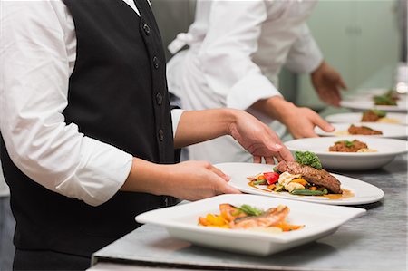 restaurante - Waitress picking up steak dinner and salmon dinner Foto de stock - Sin royalties Premium, Código: 6109-07601134