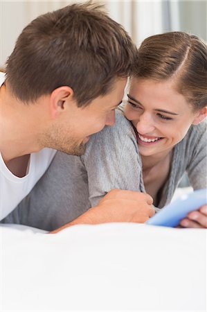 simsearch:6109-07601273,k - Happy couple on bed using tablet pc Stock Photo - Premium Royalty-Free, Code: 6109-07601260