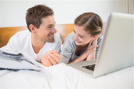 simsearch:6109-07601273,k - Happy couple on bed using laptop Stock Photo - Premium Royalty-Free, Code: 6109-07601262