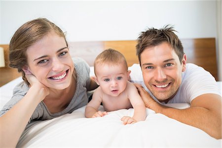 dad crawling - Happy parents lying on bed with baby son Stock Photo - Premium Royalty-Free, Code: 6109-07601277