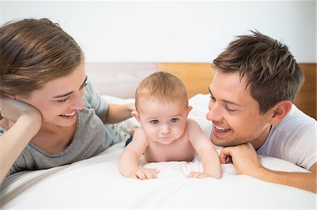 simsearch:6109-07601273,k - Happy parents lying on bed with baby son Stock Photo - Premium Royalty-Free, Code: 6109-07601276