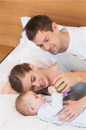 simsearch:6109-07601273,k - Happy parents relaxing on bed with their baby son Stock Photo - Premium Royalty-Free, Code: 6109-07601285