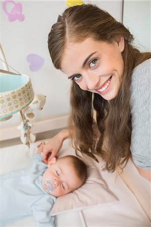 simsearch:6109-08945217,k - Happy mother watching over baby son sleeping in crib Fotografie stock - Premium Royalty-Free, Codice: 6109-07601293