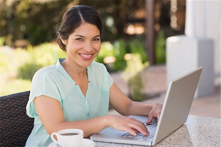 Businesswoman having coffee and working on laptop Stock Photo - Premium Royalty-Free, Code: 6109-07601203