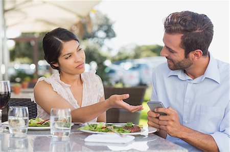 dinner outside adults - Annoyed woman taking phone from her date Stock Photo - Premium Royalty-Free, Code: 6109-07601231